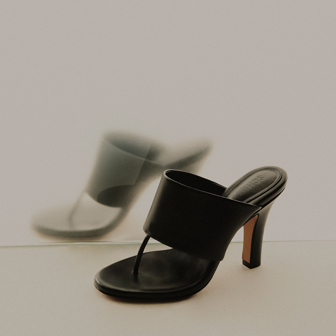 Black thong heeled sandals displayed on a neutral background, with text reading ‘Thong Sandals – Shop Now’.