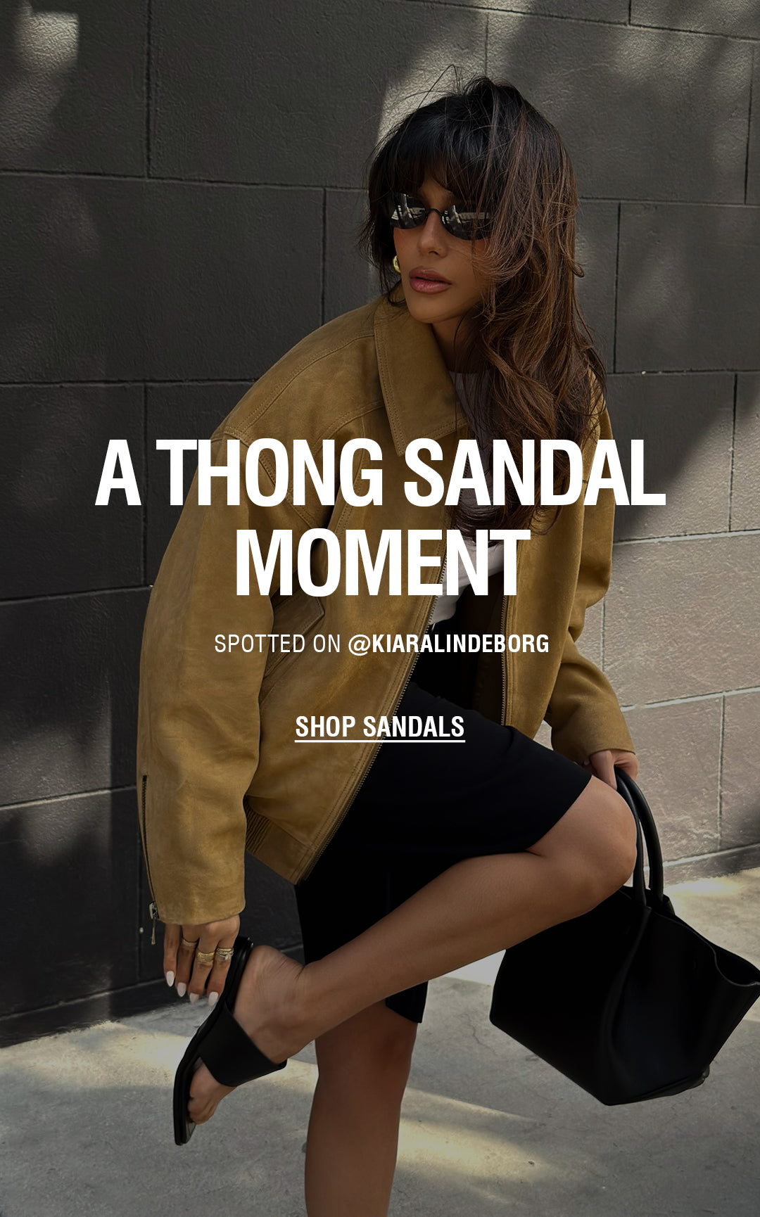 Three images of a woman wearing black thong sandals styled with black knee-length shorts, a white top, and a brown jacket, photographed on a city sidewalk. Overlaid text reads “A Thong Sandal Moment,” “Spotted on @Kiaralindeborg,” and “Shop Sandals.”