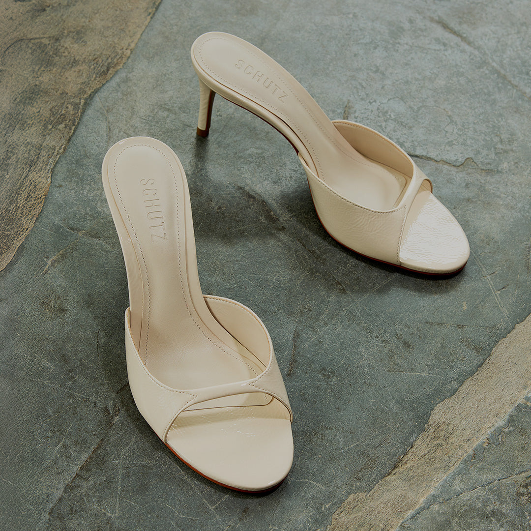Cream heeled slide sandals on a stone floor with “The Special Occasion Edit” text overlay.