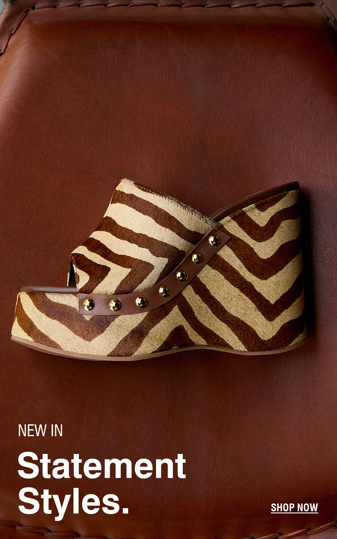 Zebra-patterned wedge shoe with stud details on a leather surface. Bold text reads "New in Statement Styles." Minimalist, fashionable tone.