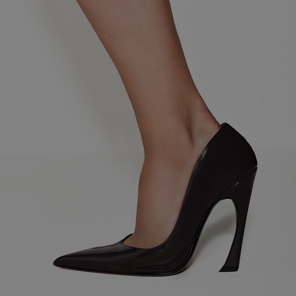 A close-up of a woman's leg wearing a sleek, black high heel with a sharp stiletto. The shoe is glossy, conveying elegance and sophistication.