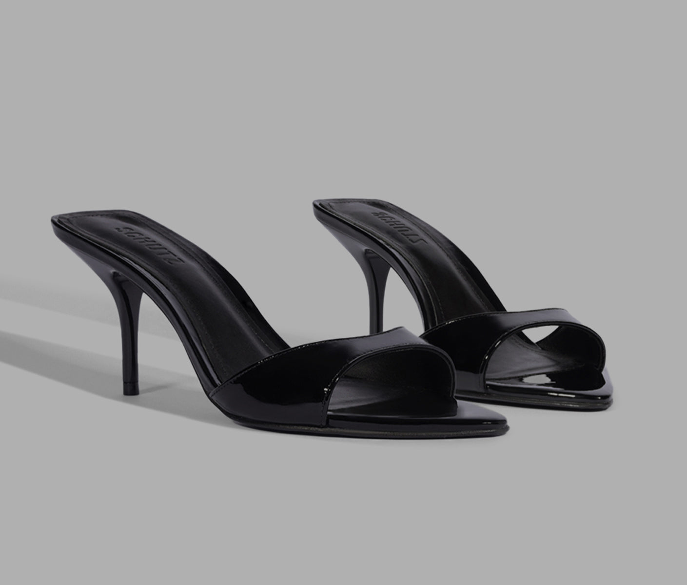 Black patent leather high-heel slide sandals with an open square toe and slip-on design.