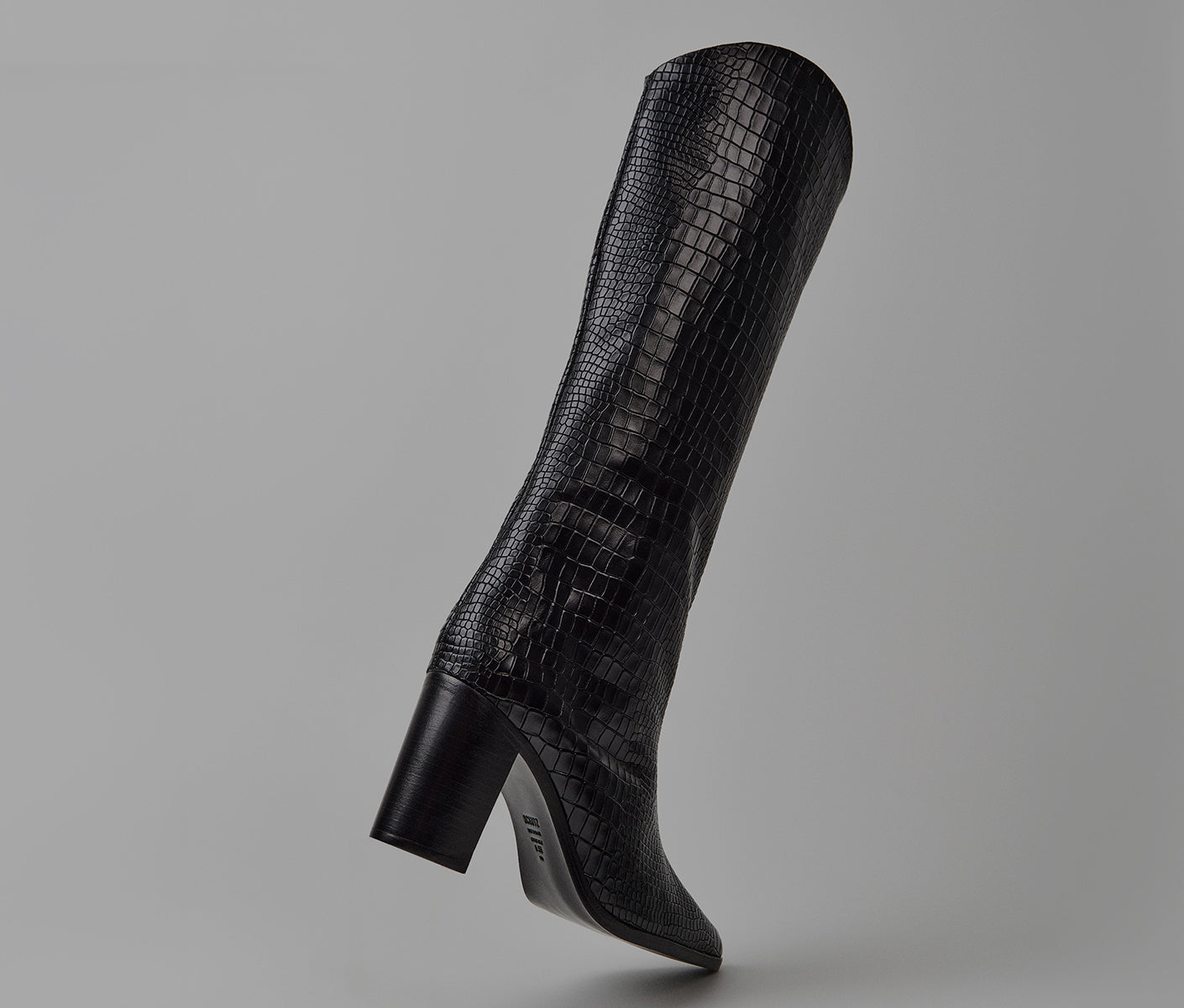 Black crocodile-embossed knee-high boot with a block heel and pointed toe.