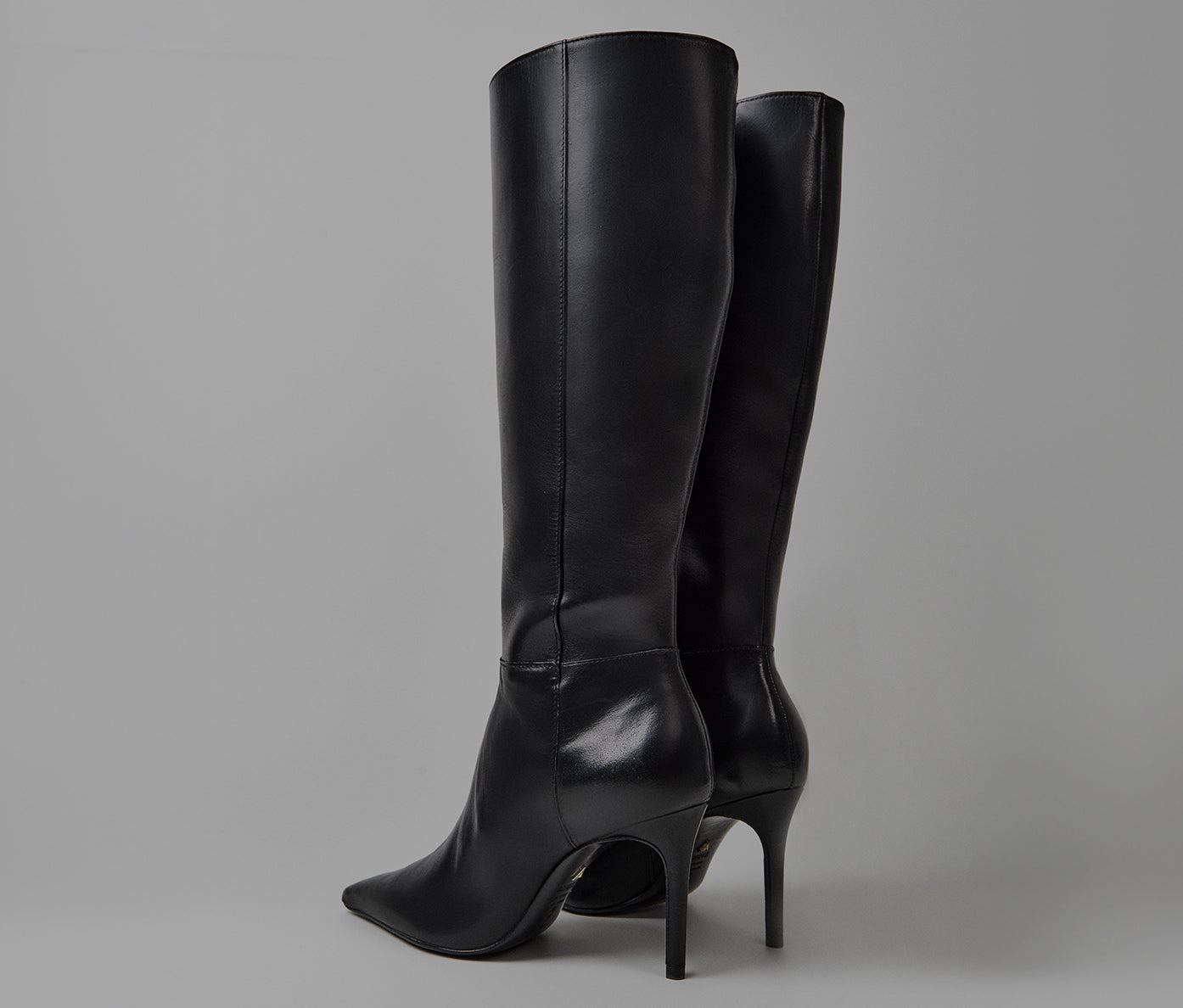 Black leather knee-high boots with pointed toes and stiletto heels.