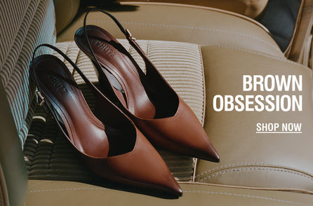 Brown leather slingback pumps with pointed toes styled on a car seat, showcasing a polished Fall look.