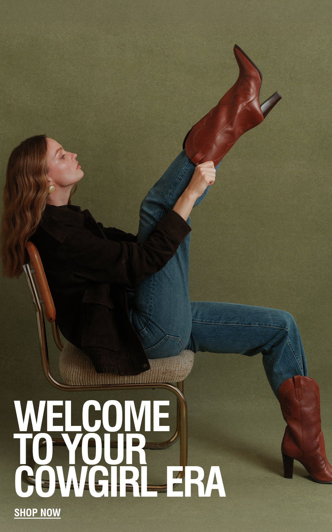 A promotional fashion image with a seated woman on a chair wearing brown leather cowboy boots, blue jeans, and a dark blazer against an olive background, alongside a close-up of a hand holding the same boot. Large text reads 'WELCOME TO YOUR COWGIRL ERA' with a smaller 'SHOP NOW' below.