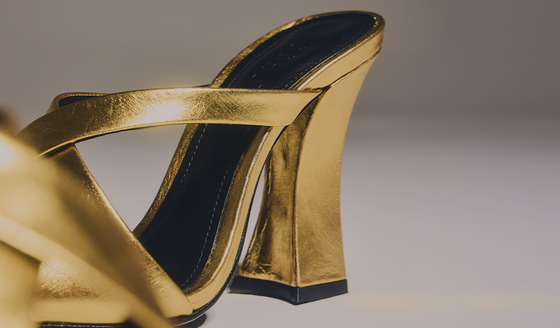 High Heels – Metallic gold high-heel sandals featuring thin crisscross straps and a sleek, polished shine. The style appears chic and feminine, perfect for dressy or evening looks.