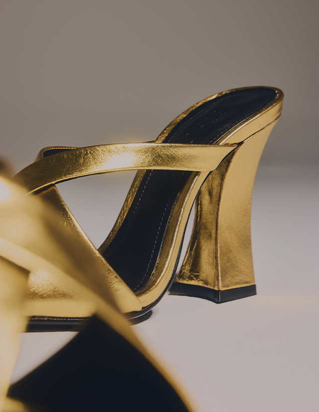 High Heels – Metallic gold high-heel sandals featuring thin crisscross straps and a sleek, polished shine. The style appears chic and feminine, perfect for dressy or evening looks.