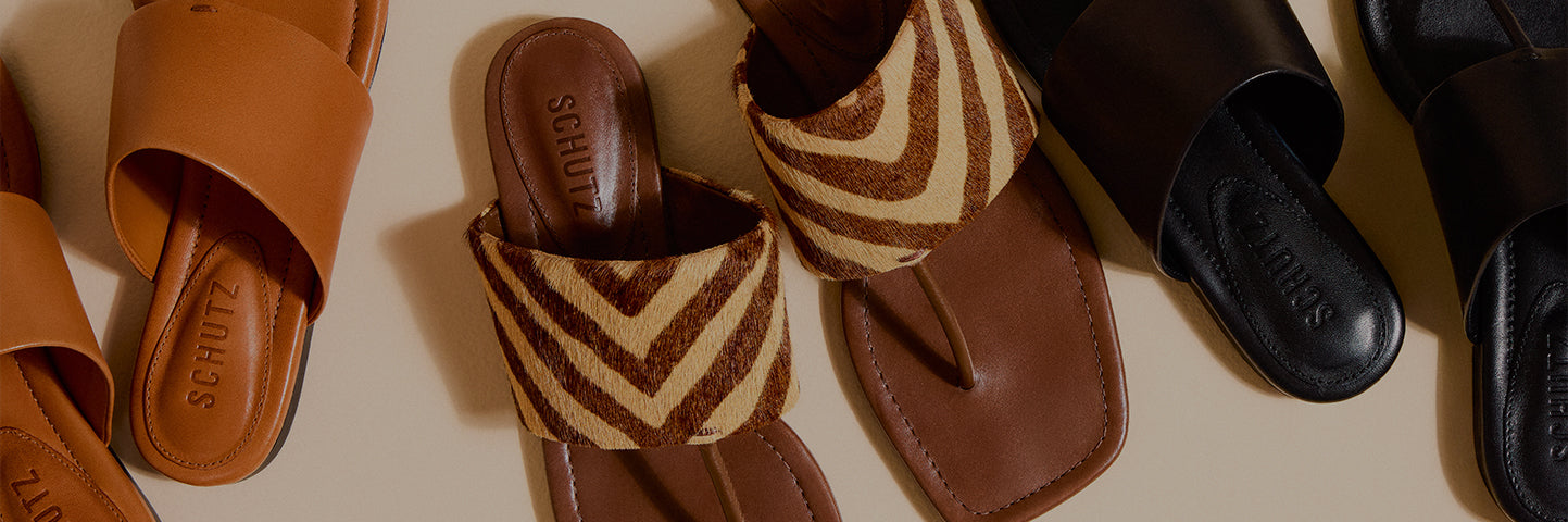 Women’s flat sandals in warm neutral shades, featuring leather finishes and animal print textures, displayed from a top-down perspective.