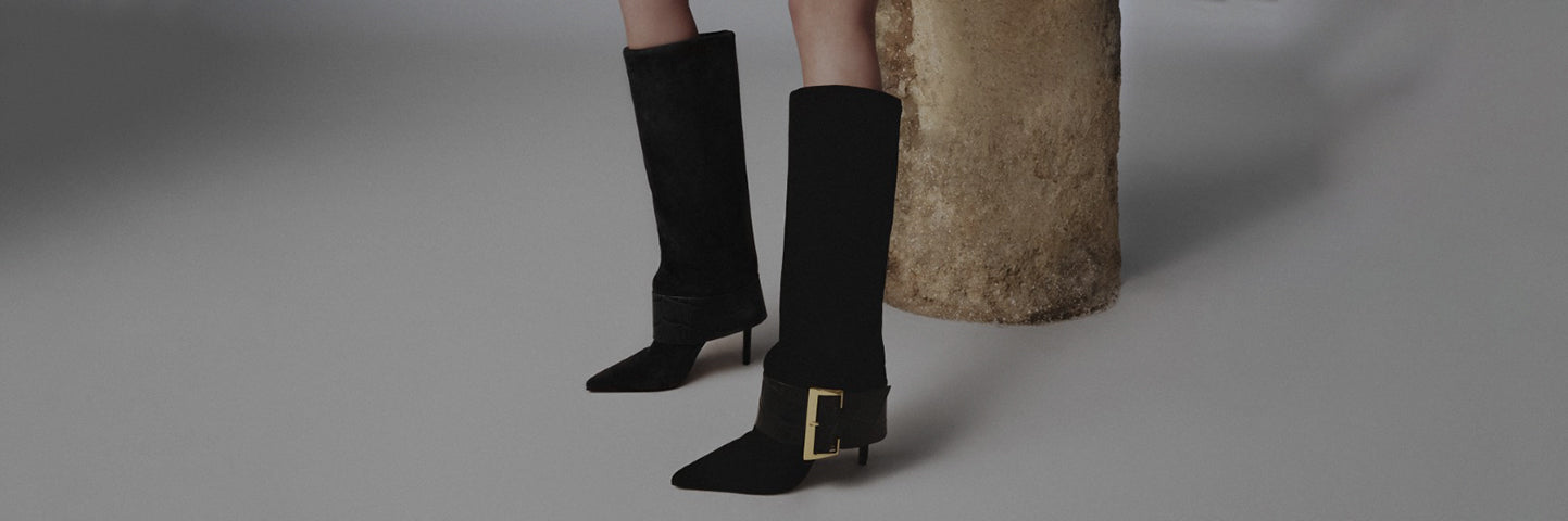 Promotional banner showing a model wearing black knee-high heeled boots with a gold buckle detail, styled against a minimalist background, with the text ‘Winter Escapes’ and a subtitle about winter style by Schutz.