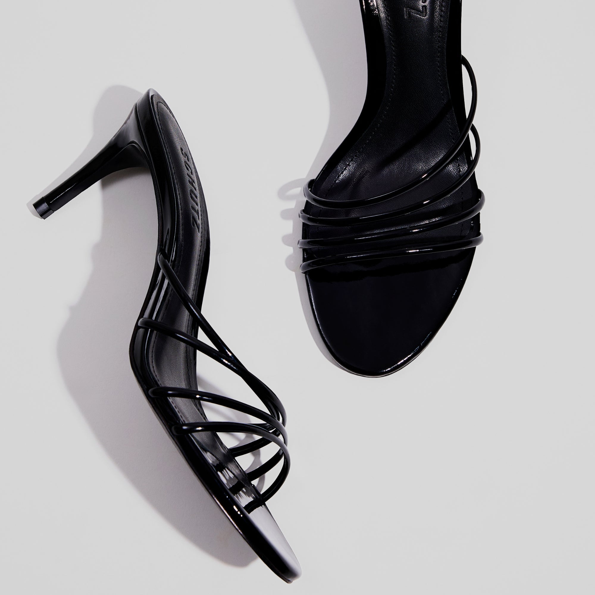best selling black strappy heels with delicate straps and sleek silhouette.