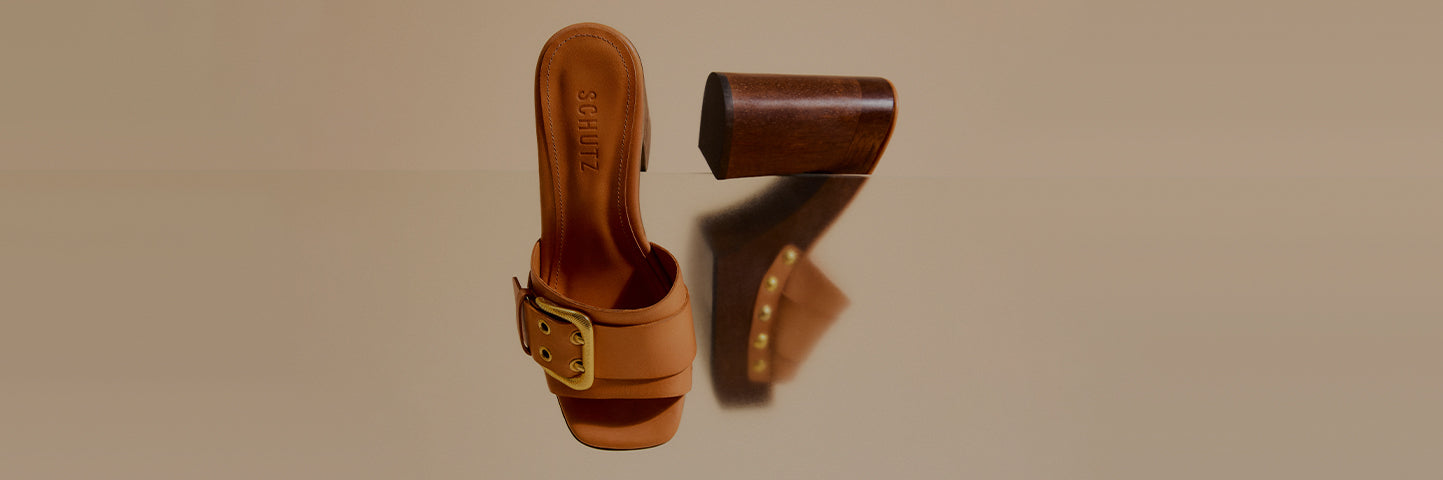 Promotional banner showing brown block-heel sandals with a wide strap and gold buckle detail, arranged against a neutral background, with the text ‘Block Heel Sandals’ and a subtitle about elevating style for work and special occasions.