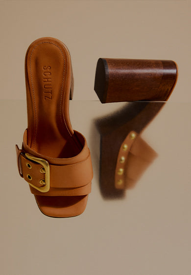 Promotional banner showing brown block-heel sandals with a wide strap and gold buckle detail, arranged against a neutral background, with the text ‘Block Heel Sandals’ and a subtitle about elevating style for work and special occasions.