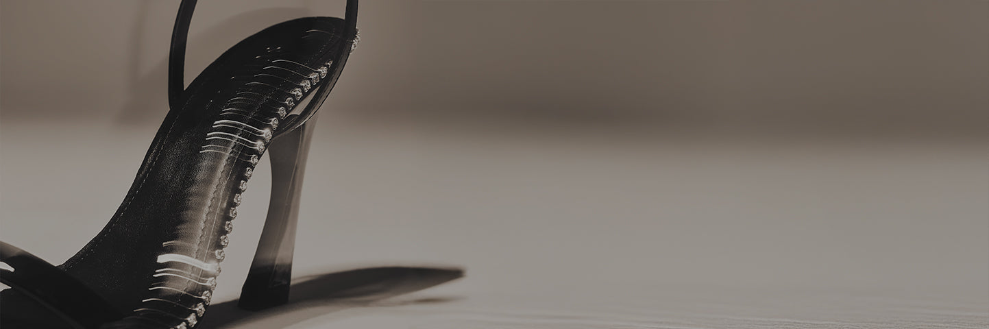 Close-up of a black high-heel sandal with thin straps and decorative rhinestones, displayed on a neutral background with the text “HIGH HEEL STYLES” on the left.