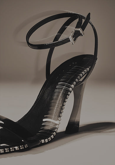 Close-up of a black high-heel sandal with thin straps and decorative rhinestones, displayed on a neutral background with the text “HIGH HEEL STYLES” on the left.