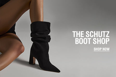 Model wearing black suede slouchy boots from Schutz Boot Shop, styled with a minimal outfit to highlight the sleek pointed-toe design and bold block heel.