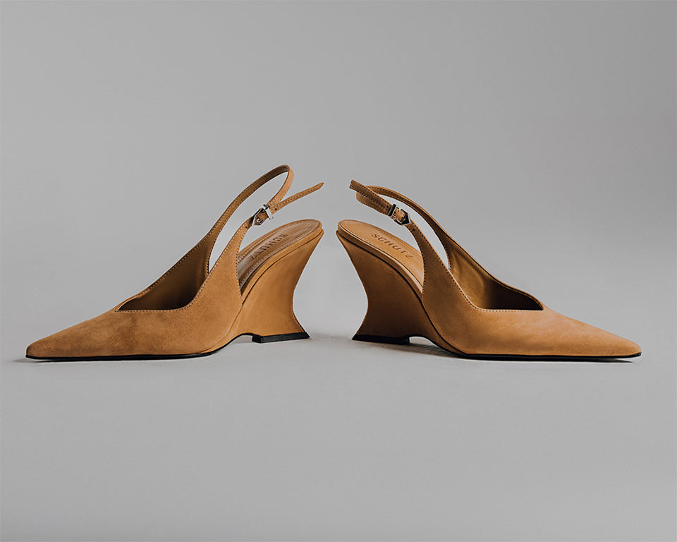 A pair of camel suede slingback pumps with sculptural wedge heels from Schutz, designed to combine sophistication and everyday power dressing.