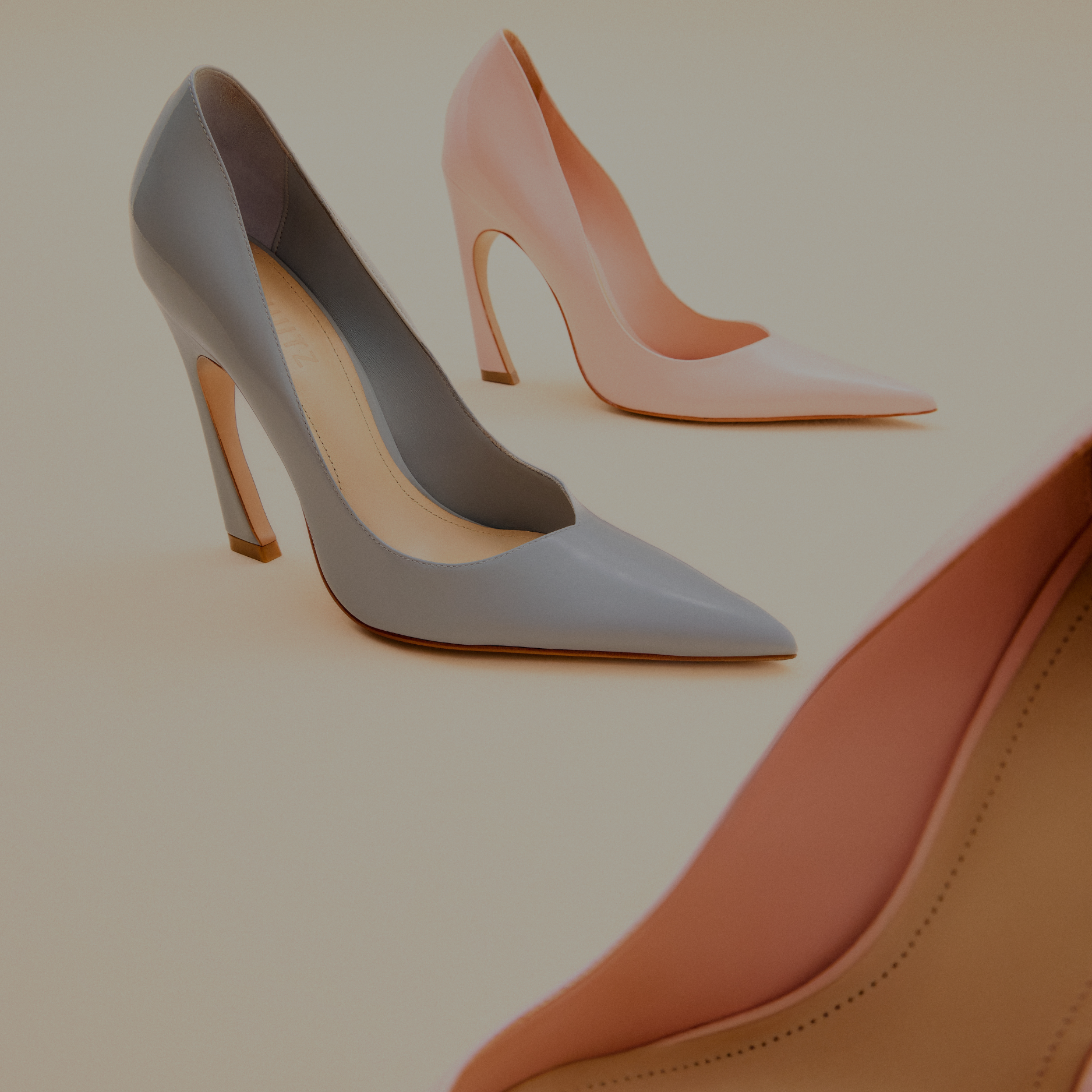 Overhead shot of two black leather slingback pumps with a deep V-cut vamp, a square toe, and a striking wedge heel, resting on a gray background.