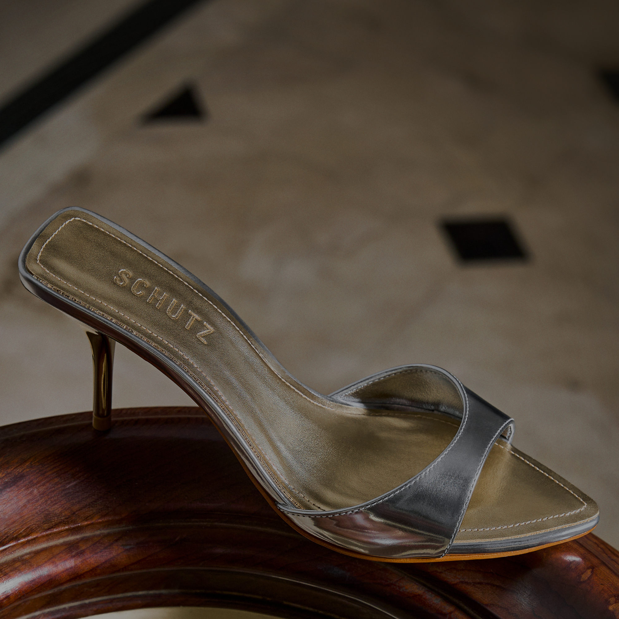 Close-up of brown leather block heel boots on a light stone surface, advertising 'STYLES UNDER $250'. Click to shop now.