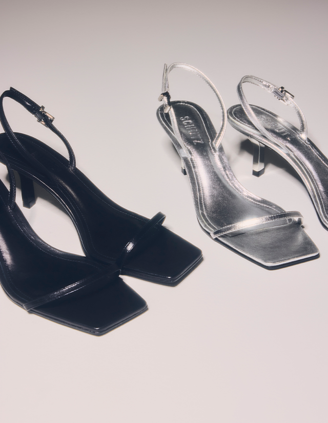 Black and transparent high-heeled sandals with square toes displayed against a neutral background.