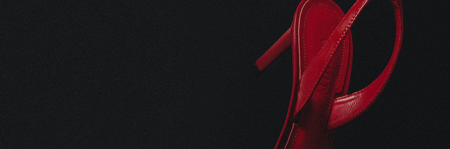 Close-up of red leather mid-heel slingback sandals with a sleek design, displayed against a dark background to highlight elegant mid-heel styles.